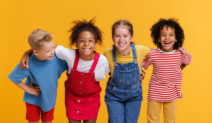 Group of cheerful happy multinational children on  yellow background - 536905540