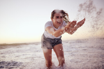 Splash, ocean and woman at the beach in the water, enjoying the waves at sunset. Summer adventure, holiday and happy girl having fun on vacation. Freedom, joy and playful female splashing in the sea