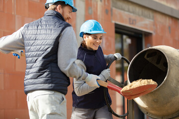 builder couple work with concrete mixe