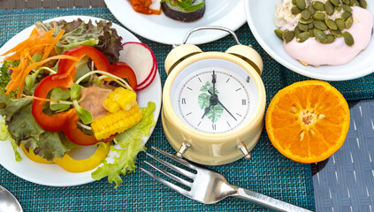 Yellow alarm clock with Intermittent fasting concept 16:8. Intermittent Fasting often use for losing weight or to control diabetes.