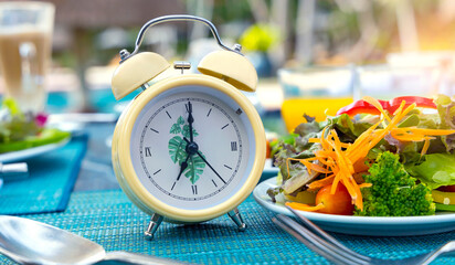 Yellow alarm clock with IF (Intermittent Fasting) 16 and 8 diet rule and weight loss concept.
