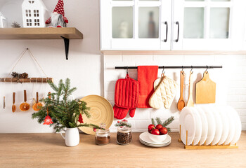 the concept of New Year's decor of a modern kitchen in light colors. front view of the countertop with kitchen utensils and decorations