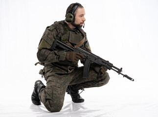 soldier in the studio on a white background. a man in military uniform with a rifle or machine gun. military or airball player