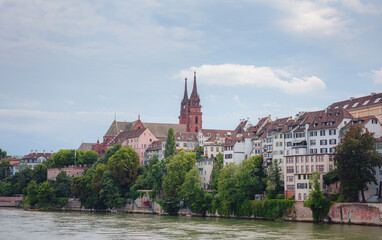 Fototapeta premium Buildings in the city centre of Basel and the Rhine river, Switzerland. Riverside of swiss city with Basel Cathedral