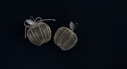 Decorative apples made of thin metal on a black background