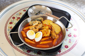 tteokbokki on silver aluminum tray, stir-fried rice cake and fried.
