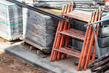 Pallets with gray paving slabs at a construction site. Plastic packaging protects the tiles from atmospheric effects. Preparation for installation. close-up. selective focus. Blurry background.