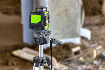 Laser level on a tripod at a construction site. Close-up. Taking measurements with a laser.