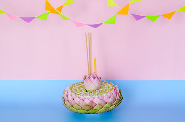 Pink lotus petal krathong that have 3 incense sticks and candle decorates with lotus and crown...