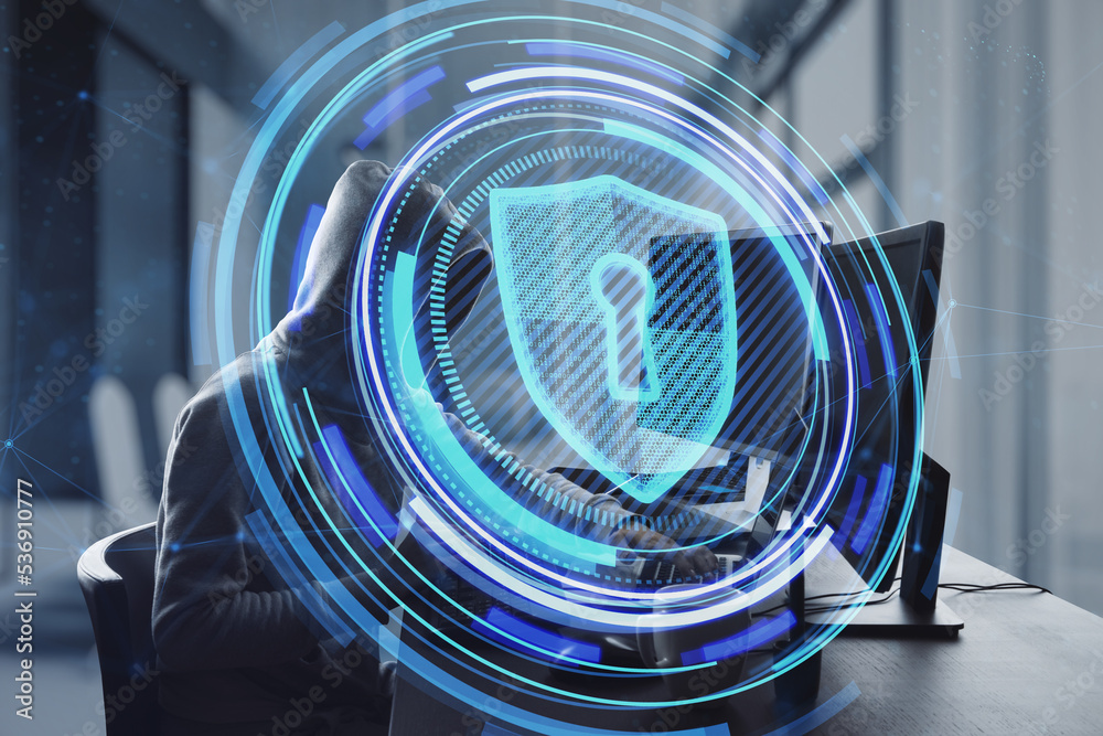 Poster Side view of hacker at desktop using laptop with glowing shield hologram on blurry office interior background. Secure, data theft, malware, safety and web protection concept. Double exposure.