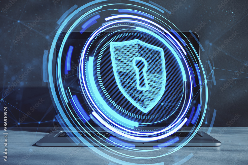 Poster close up of laptop on desktop with creative glowing blue shield hologram on blurry background. secur