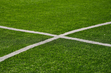 Close up detail field of the artificial grass from a brand new soccer field, view with the white marking line.