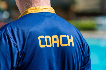 Fototapeta premium Back view of swimming coach, wearing COACH shirt