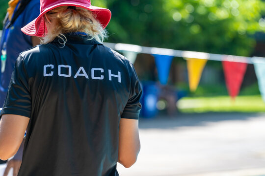 Back view of swimming coaches, wearing COACH shirt