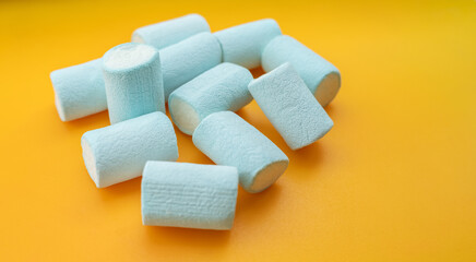 Blue marshmallows on orange background.