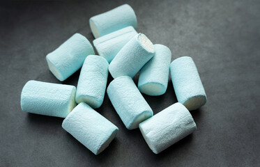 Blue marshmallows on dark background.
