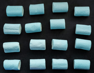 Blue marshmallows on dark background.