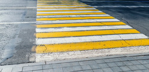 Detail of a yellow crosswalk on the road.