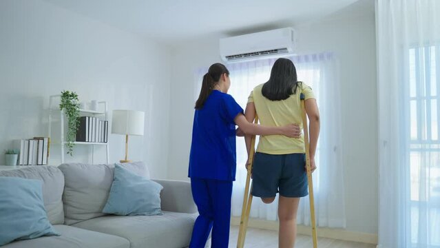 Asian female leg amputee doing physiotherapy with support from nurse.