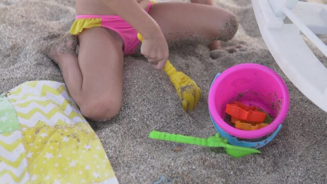 A little girl plays with toys on a sandy beach. Turkey, Alanya