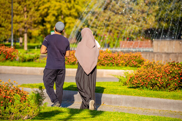 Muslim family spend time together in the park. Girl in a hijab. Romantic Muslim couple in love with a baby in their arms.