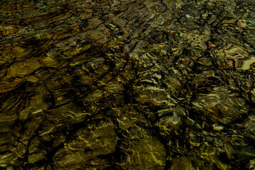 Defocus blurred transparent blue colored clear calm water surface texture with splash, bubble. Shining blue water ripple background. Surface of water in swimming pool. Blue bubble water shining.