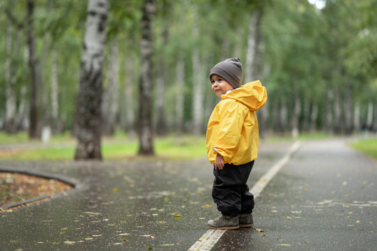 Baby boy wearing yellow rain jacket on road