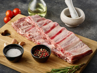 Raw pork ribs with spices, salt, pepper and rosemary. Fresh pork. Pig ribs.