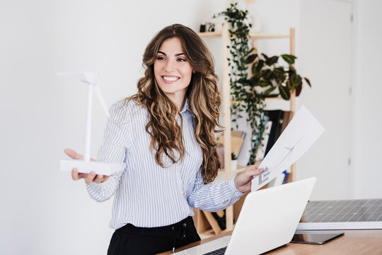 Young Entrepreneur Holding Windturbine Model In Sustainable Office