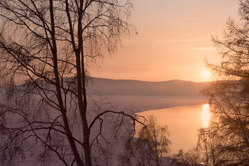 Beautiful sunset on frozen lake Baikal. Winter landscape.