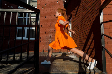 Woman in orange dress doing warm up on sunny day