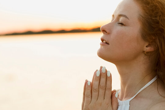 Beautiful Woman With Hands Clasped At Sunset