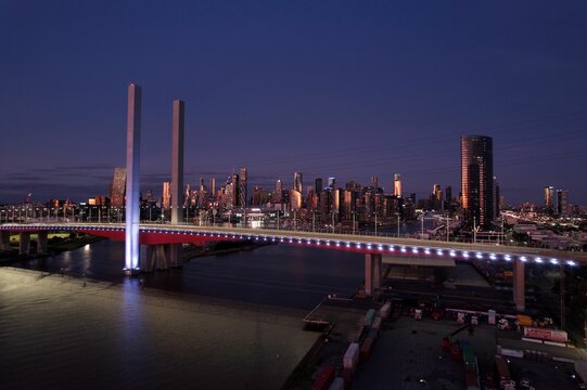 Drone shot of the Bolte Bridge and the cityscape of Melbourne under dark dusk sky after sunset