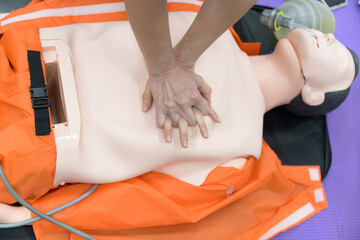 Demonstrating CPR (Cardiopulmonary resuscitation) training medical procedure on CPR doll in the...