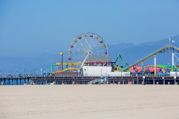 Photo for Pacific Park with Ferris Wheel on the Santa Monica Pier over Beach Sand on Bright Sunny...