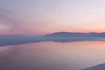 Fototapeta na wymiar Beautiful sunset on frozen lake Baikal. Winter landscape.