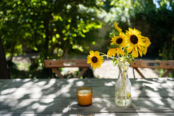 Candle and flower vase on table