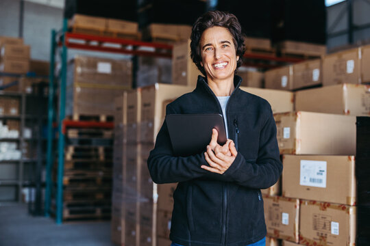 Female warehouse supervisor smiling at the camera happily