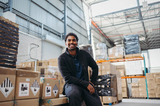 Logistics worker smiling happily while working in a distribution warehouse