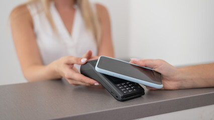 A woman pays using a non -contact payment of the NFC used by a smartphone. 