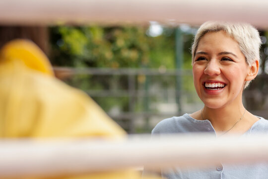 Happy non-binary person having fun with friend