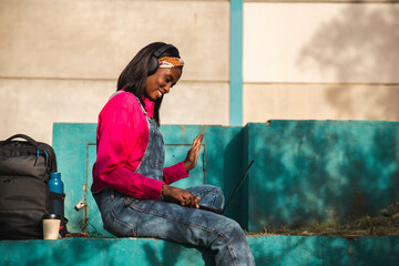 Young freelancer gesturing ion video call through laptop on wall