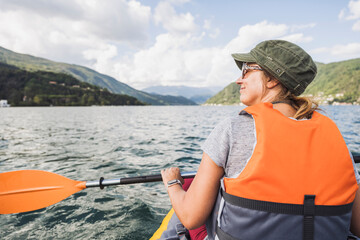 Smiling mature woman kayaking at lake