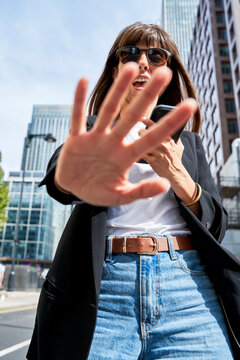 Mature Woman Showing Stop Gesture With Hand On Sunny Day