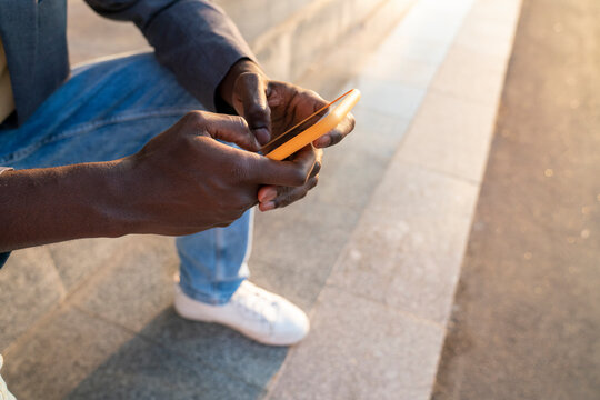 Hands of businessman using smart phone on steps