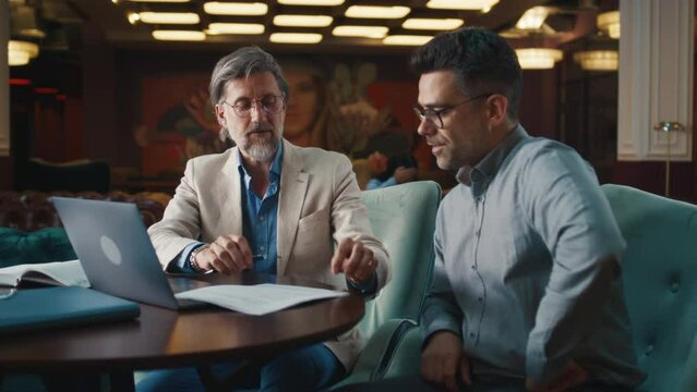 Serious businessman making deal, signing contract for successful partnership. Business meeting in office restaurant. Companies cooperation agreement. Businesspeople shaking hands