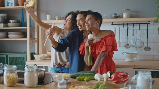 Beautiful young women spending time together and having fun. Latin and hispanic girls lifestyle moments in the kitchen while cooking. Representation of happy friends laughing and sharing good vibes