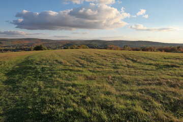 Jesienny widok na łąkę i niskie góry.