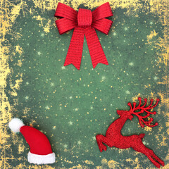 Festive Christmas background with bow, santa hat and reindeer tree bauble decorations in red on...