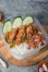 Rice with side dishes of squid and cucumber added with peanuts served on a wooden board